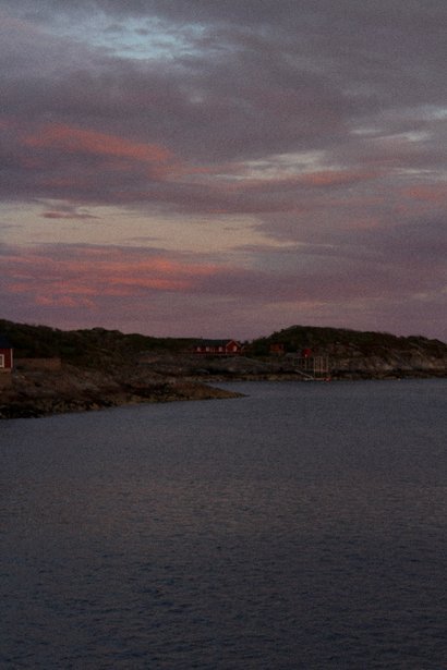 Pink sky over dark water after dusk in Lofoten
