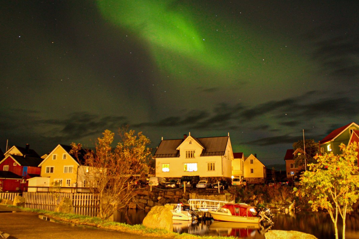 Northern lights over illuminated houses in a Lofoten village